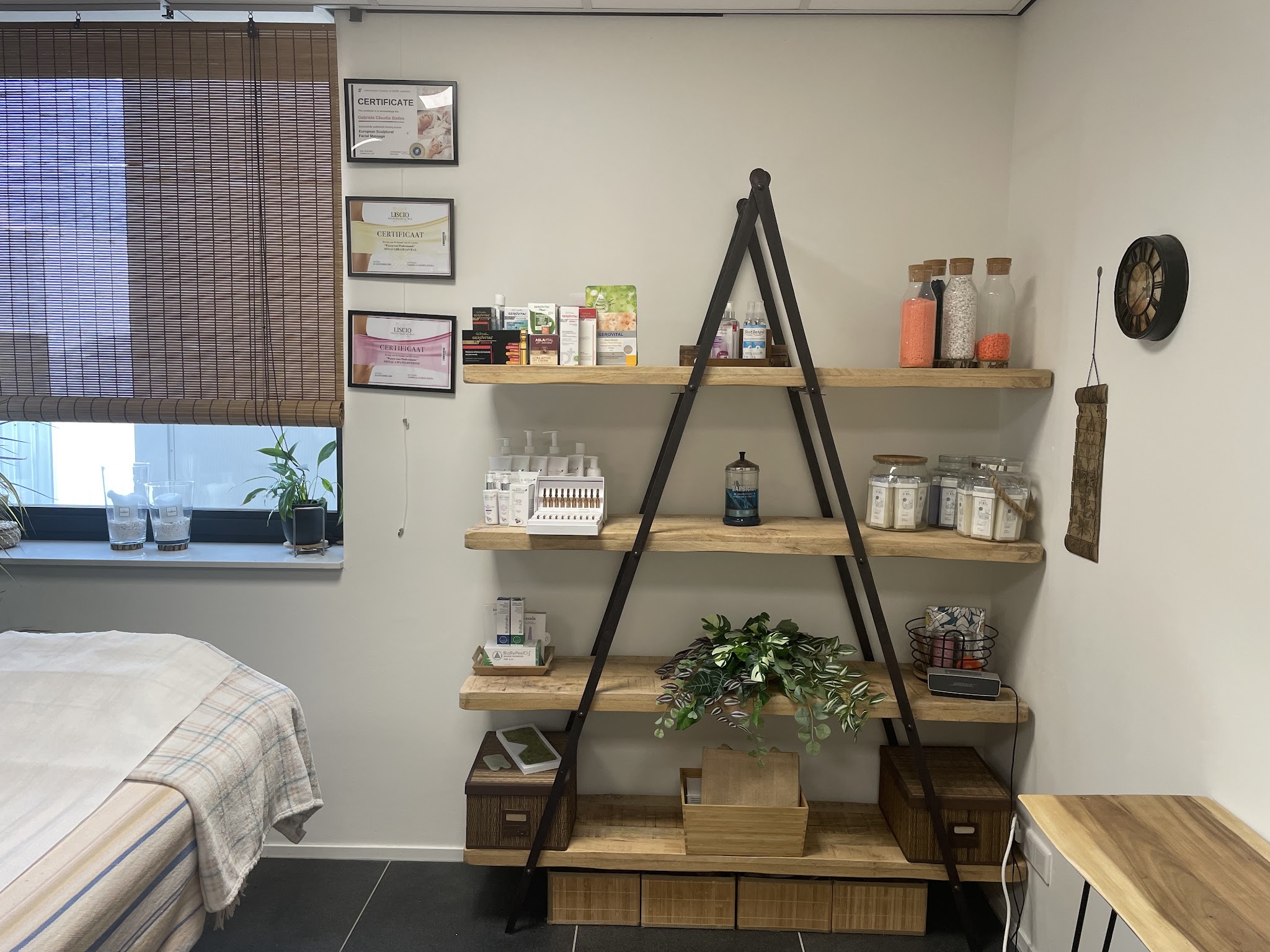 Houten ladderrek met producten, een plant en een wandklok in de studio