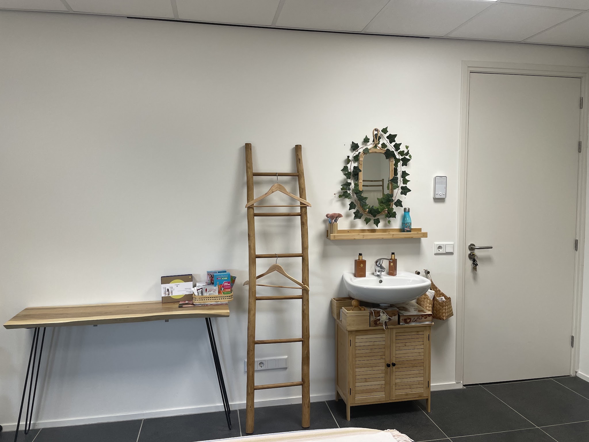 Hoek met wastafel, spiegel, houten ladderrek en een houten wandtafel